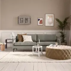Gemütliches Wohnzimmer: Ein grünes Sofa, ein beiger Hocker und ein flauschiger Teppich verwandeln jeden kleinen Raum einrichten.