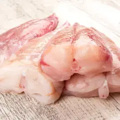 Surowe kawałki ryby miętus, gotowe do przygotowania. Ich delikatny smak zachwyci każdego smakosza.