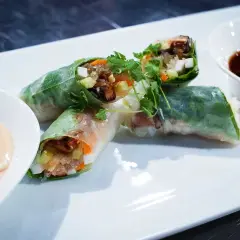 Färska vietnamesiska vårrullar med grönsaker och nudlar, serverade med två dippsåser. Perfekt som förrätt eller lätt måltid.