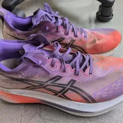 Para biegowych butów Asics Megablast w kolorze fioletowo-pomarańczowym, gotowych na kolejny trening.