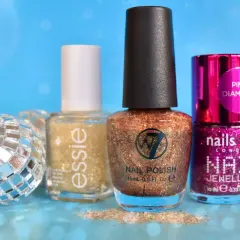 Glittrigt w7 nagellack i kopparfärg, bredvid Essie och Nails Inc. En discokula och glitter ger festlig känsla.