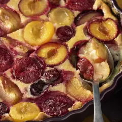Un délicieux clafoutis aux prunes, aux couleurs vives et à la texture moelleuse, prêt à être dégusté.