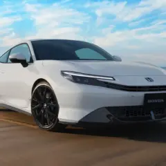 El Honda Prelude 2026 blanco, con su diseño deportivo, se luce en la playa bajo un cielo azul.