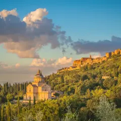 La chiesa rinascimentale e il borgo medievale, incastonati tra colline verdi, mostrano dove si trova Montepulciano al tramonto.