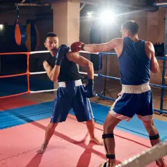 Two boxers spar in a ring, demonstrating how to fight boxing with jabs and defensive moves.