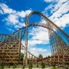 Drewniany rollercoaster w Energylandii, z czerwonymi torami i niebieskim niebem. To prawdziwa zadra przeciążenia, która wznosi się ku chmurom.