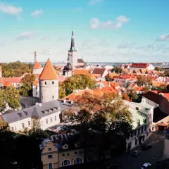 Widok na zabytkowe wieże i czerwone dachy Tallinna, stolicy Estonii, w słoneczny dzień.