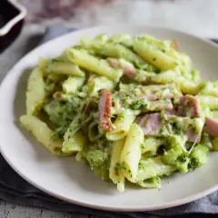 Penne z brokułami i kawałkami szynki w kremowym sosie śmietanowym, posypane serem. Pyszne danie, które zachwyci każdego.