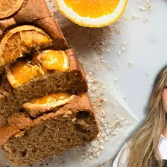 Un delicioso bizcocho de naranja, decorado con rodajas de naranja y avena, junto a una mujer sonriente.