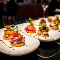 Petits amuse-bouches colorés sur des assiettes blanches, une recette entrée originale et raffinée.