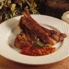 Saftiga spareribs i ugn, serverade med en smakrik tomatsalsa och garnerade med färska örter. En härlig måltid!