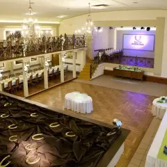 Elegancka sala weselna z podkowami szczęścia i stołami nakrytymi na przyjęcie.