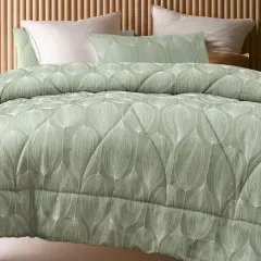 A sage green coverlet with a white leaf pattern. This coverlet serves as a decorative top layer for the bed, adding warmth and style.
