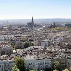 Widok na gęstą zabudowę miejską Szczecina z dominującymi kamienicami i wieżami kościołów.