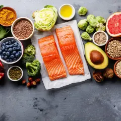 Zdrowe składniki na dietę na stłuszczoną wątrobę: łosoś, jagody, awokado, orzechy, nasiona, warzywa i owoce.