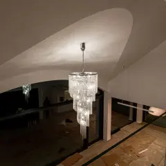 Elegancki zwis do lampy z kryształkami lśni w nowoczesnym wnętrzu z wysokim sufitem.
