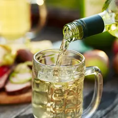 Wino z jabłek 10l nalewane do kufla. Na stole jabłka i przekąski.
