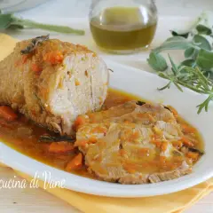 Succulento arrosto di vitello al forno, affettato e servito in un sughetto saporito con carote e erbe aromatiche.