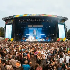 Riesige Menschenmenge feiert bei Juicy Beats 2025. Eine Bühne mit Lichtern und Bildschirmen, auf denen "Juicy Beats" steht, ist im Hintergrund zu sehen.