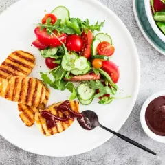 Grillowany ser halloumi z sosem barbecue i świeżą sałatką z pomidorów i ogórków.