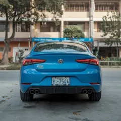 Vue arrière d'une voiture bleue. Le **code couleur voiture carte grise** est bien visible sur la plaque d'immatriculation.