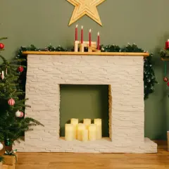 Festliche Szene mit geschmücktem Weihnachtsbaum, selbstgebauter Kaminkonsole, Kerzen und Geschenken.