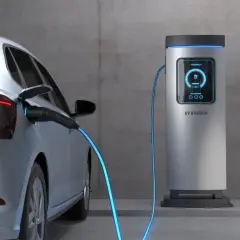 Srebrny elektryk podłączony do stacji ładowania. Sprawdź, jaki jest koszt ładowania elektryka i zacznij oszczędzać.