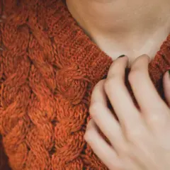 Ciepły, pomarańczowy sweter z warkoczami. Idealny na 14 stopni, gdy zastanawiasz się, jak się ubrać.