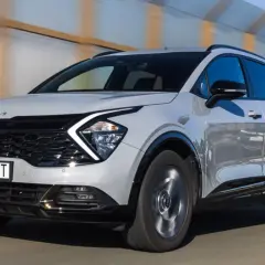 Nowa Kia Sportage w kolorze jasnoszarym pędzi po drodze. Zastanawiasz się, ile kosztuje nowa Kia Sportage?