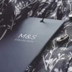 Étiquette M&S Collection sur un tissu fleuri. Astuce pour savoir comment décoller une étiquette sans l'abimer.