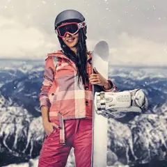Kobieta w stroju narciarskim trzymająca snowboard na tle gór.