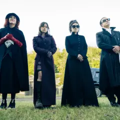 Rollistan i Beetlejuice 2: fyra personer i mörka kläder står på en kyrkogård.