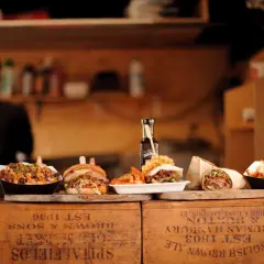 Kebab, burger, frytki i inne dania na drewnianych skrzynkach.