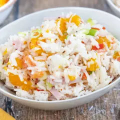 Reissalat mit Mandarinen, Schinken und Frühlingszwiebeln in einer Schüssel. Ein erfrischender Salat für warme Tage.