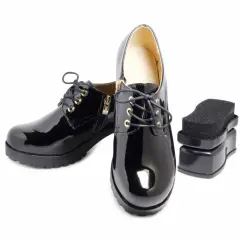 Paire de chaussures vernies synthétiques noires avec un applicateur de cirage. Parfait pour l'entretien des chaussures vernies synthétiques.