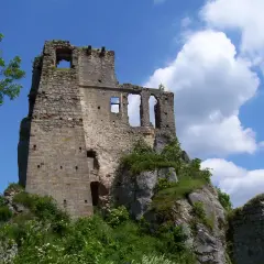Ruiny zamku Odrzykoń na skalistym wzgórzu, z zielenią i błękitnym niebem.