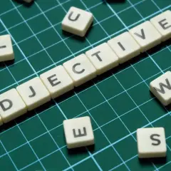 Tessere con lettere formano "ADJECTIVE". Alcune lettere sparse, come "S", suggeriscono la creazione di aggettivi con s.