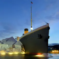 A replica of the Titanic ship is shown at dusk, with an iceberg and the White Star Line building.
