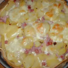 Tarte façon raclette, garnie de pommes de terre, lardons et fromage fondant. Un délice réconfortant !
