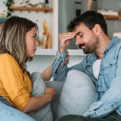 Kobieta pociesza mężczyznę zmagającego się z filofobią, jego ręka na czole wskazuje na stres.