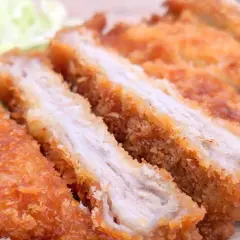 Juicy, baked tonkatsu, sliced and served with shredded cabbage. A delicious and crispy meal.
