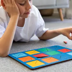 Chłopiec z ADHD układa kolorowe klocki na dywanie. To świetne zabawy dla dzieci z ADHD, rozwijające koncentrację i zdolności manualne.