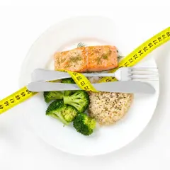 Gesundes Essen für schnelles Abnehmen: Lachs, Brokkoli und Reis, umgeben von einem Maßband.