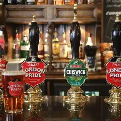 Jak zaplanować zapas piwa na imprezę? Keg vs butelki kalkulacja. Piwo London Pride i Chiswick Bitter na ladzie pubu.