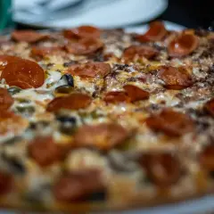 Pyszna pizza z pepperoni i oliwkami, idealna do pieczenia w wysokiej temperaturze.