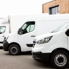 Rząd białych samochodów dostawczych, idealnych do leasingu. Gotowe do pracy i transportu.