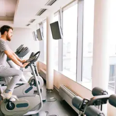 Mężczyzna ćwiczy na rowerze stacjonarnym, który może być dobrym wyborem, jeśli zastanawiasz się, jaki rower stacjonarny do rehabilitacji kolana.