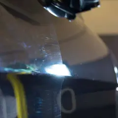 Widoczne rysy na lakierze ciemnego auta. Pokazuje, jak polerować auto, by przywrócić mu blask.