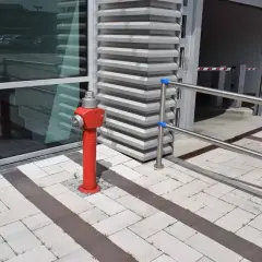 Ein roter hydrant steht auf einem gepflasterten Weg. Er ist bereit, im Notfall eine hohe hydrant durchflussmenge zu liefern.