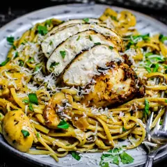 Ein Teller cremiger Pasta mit gebratenem Hähnchen, Pilzen und Parmesan. Dieses Chicken Alfredo Gericht sieht köstlich aus.